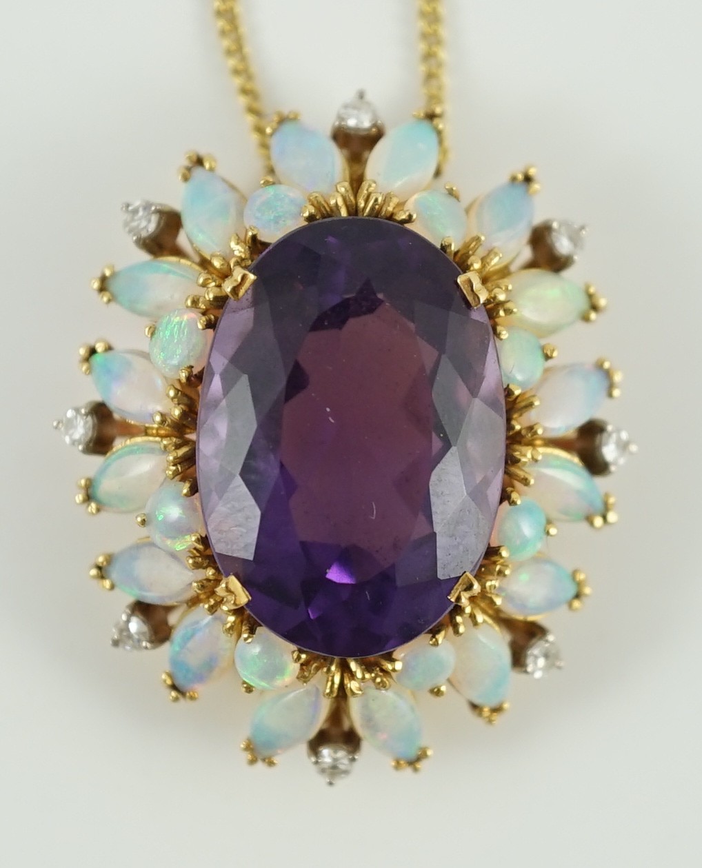 A modern 18ct gold and oval cut amethyst set pendant, with round and marquise cut white opal and round cut diamond set border, on an 18ct gold fine link chain